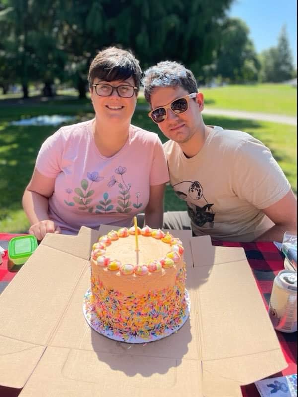 Camille & Romain in front of a cake